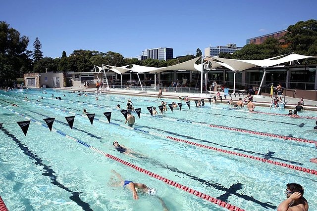 People enjoying the outdoor pool at Victoria Park Pool on a sunny day