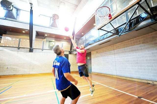 Two males playing a basketball competition on the indoor stadium at Cook + Phillip Park Pool