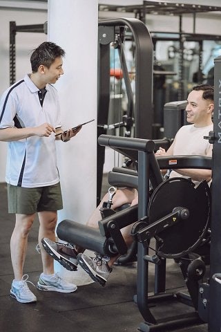 Personal trainer supports participant by tracking progress on a tablet device