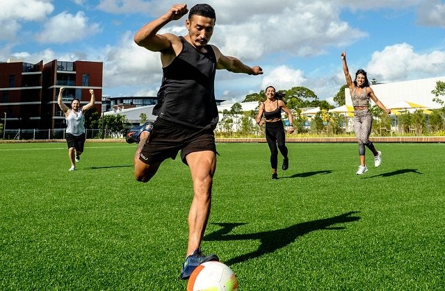 People playing football on the multipurpose sports field at Gunyama Park