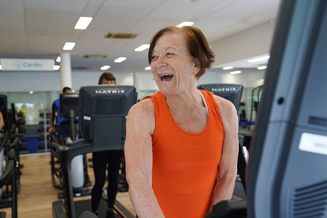 Older female smiling while exercising in the fitness centre of the Ian Thorpe Aquatic Centre