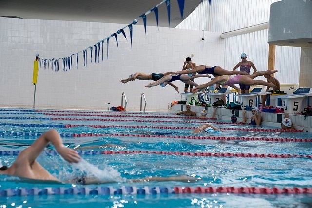 Group of squad swimmers dive into the 50m pool at Ian Thorpe Aquatic Centre