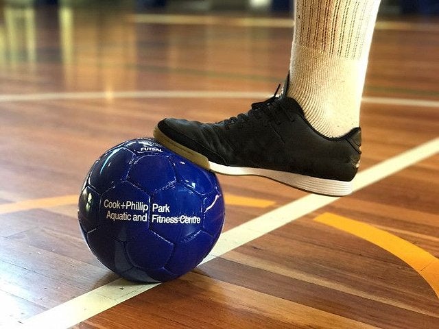 Futsal ball held under foot on the Cook + Phillip Park Pool sports court