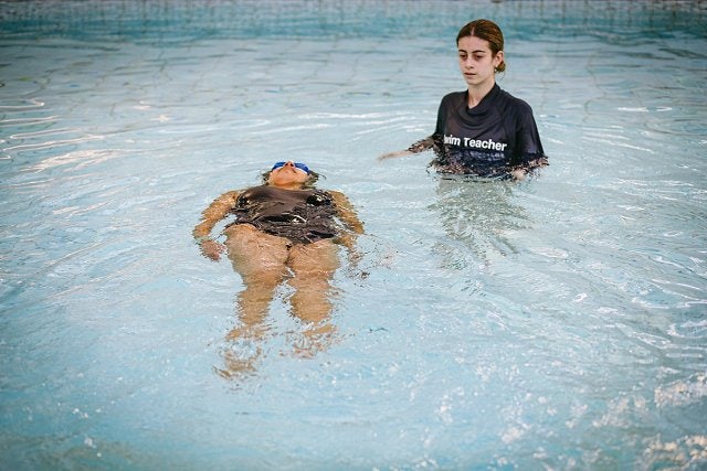 Swim teacher in the pool with a female student at Cook + Phillip Park Pool