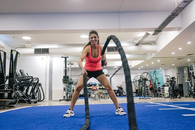 Female participant working out in the fitness centre at Cook + Phillip Park Pool using battle ropes